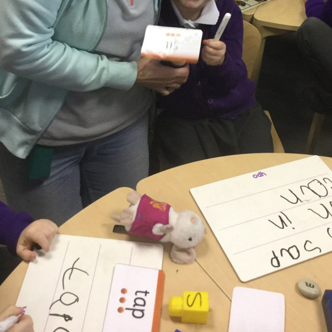 A child and grandparent are taking part in a writing activity at school.