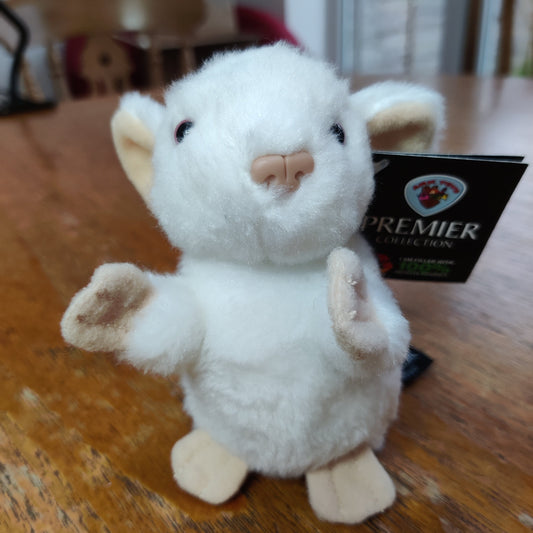 A white toy mouse sits on a dining room table.