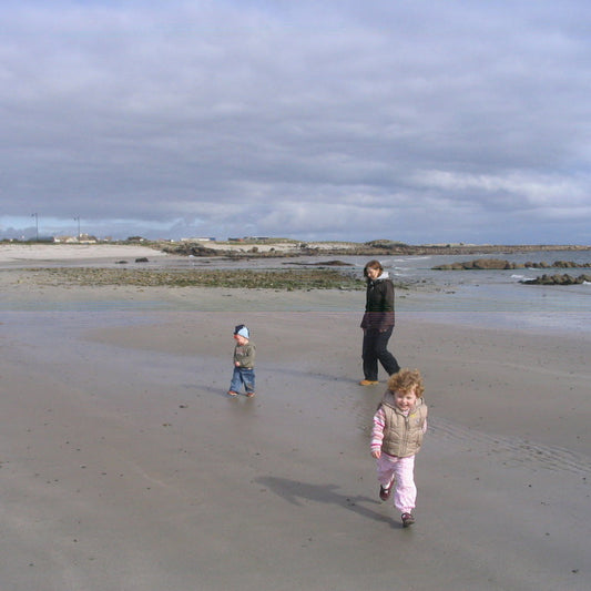 Family with 3–4-year-old child playing active games on the beach